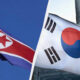 Two Korean flags displayed side by side: left is North Korea, right is South Korea, both waving in the wind.