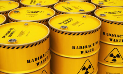 Yellow radioactive waste barrels arranged in rows with hazard symbols on the drums