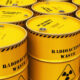 Yellow radioactive waste barrels arranged in rows with hazard symbols on the drums