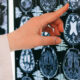 Doctor's hand points to a brain MRI scan on film, highlighting a specific region on the image.