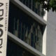 Vertical banner on a gray building reading 'ARMORY' with 'SEATTLE CENTER' text, against windows and tree branches in the foreground.