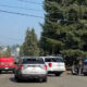 Fire truck and red emergency vehicle block a residential street as responders work behind police tape.