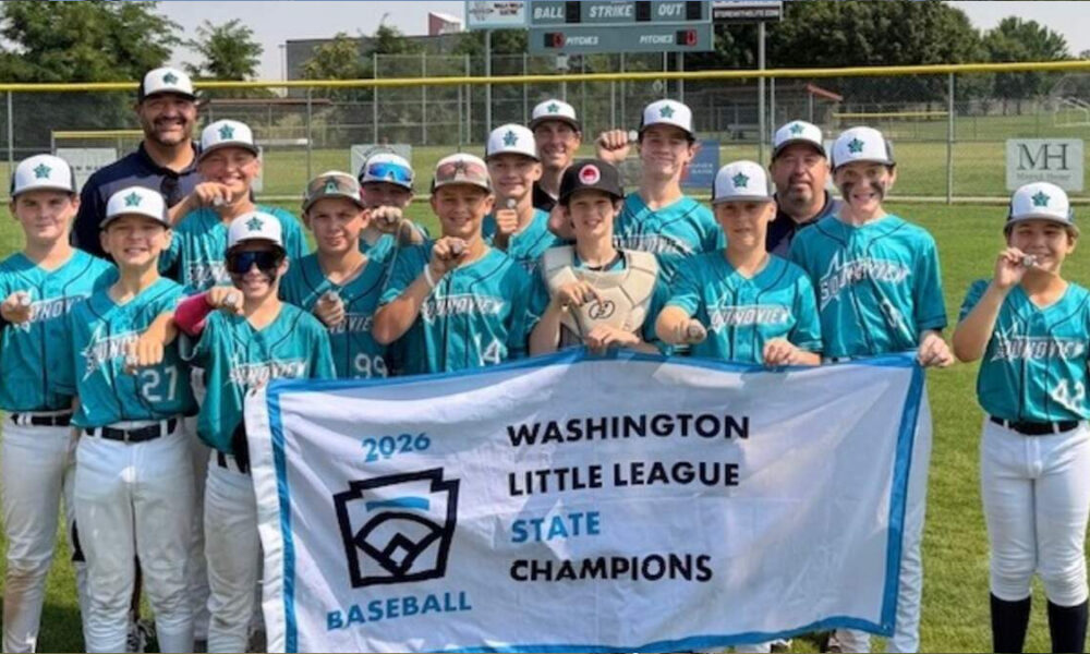Youth baseball team in teal jerseys posing with banner that reads 'Washington Little League State Champions 2026' on a sunny field.