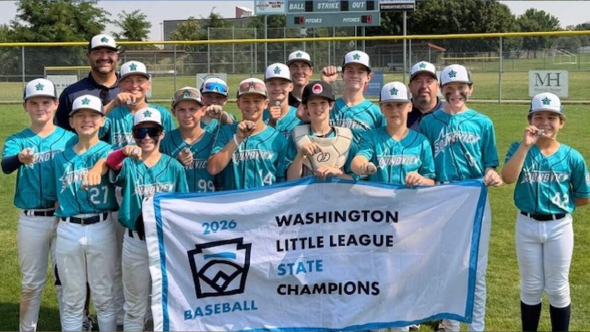 Youth baseball team in teal jerseys posing with banner that reads 'Washington Little League State Champions 2026' on a sunny field.