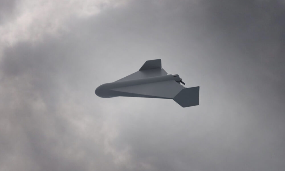 White unmanned aerial vehicle (drone) with swept wings flying through a cloudy sky.