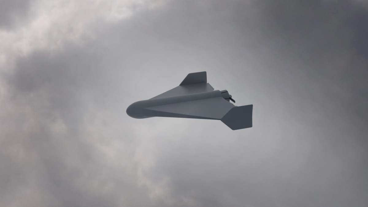 White unmanned aerial vehicle (drone) with swept wings flying through a cloudy sky.