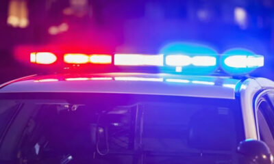 Police car with red and blue emergency lights flashing at night.