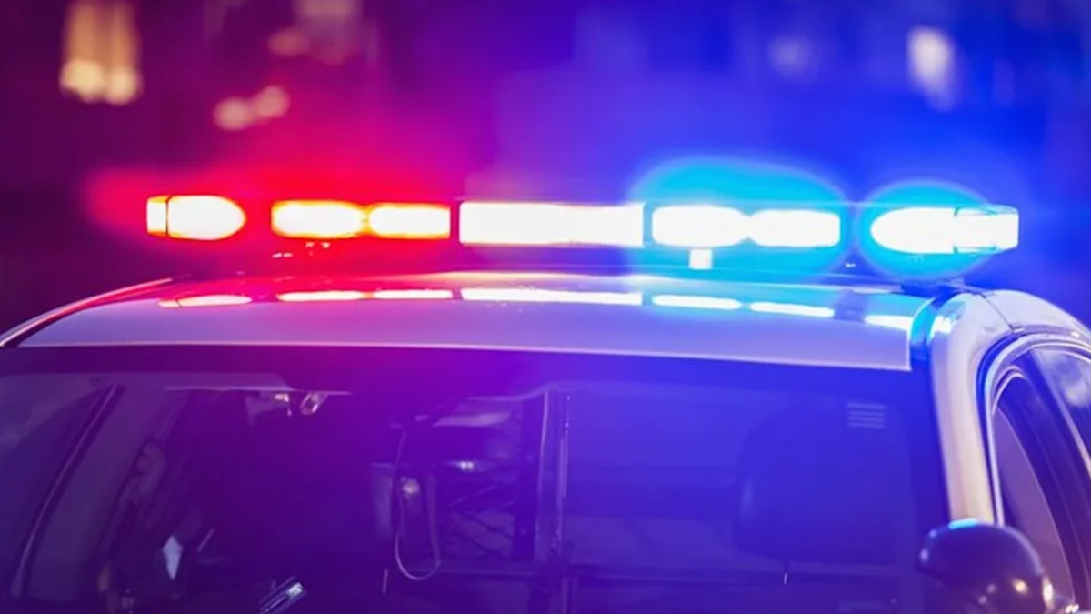 Police car with red and blue emergency lights flashing at night.
