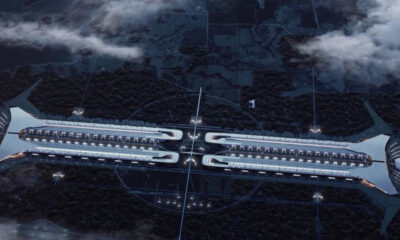 Futuristic space station with twin parallel modules connected in the center, hovering above a dark, forested planet surface at dusk.