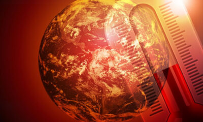 Globally warming theme: Earth with a large thermometer overlay signaling rising temperatures.