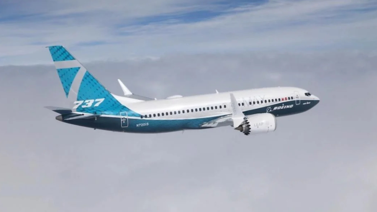 Boeing 737 MAX in flight with blue-turquoise tail and white fuselage, engine visible under the wing.
