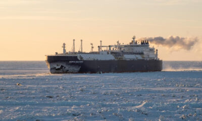 Icebreaker Boris Davydov moving through sea ice at sunset, steam plume trailing from the stack.