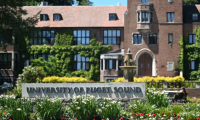 Campus fountain and a brick university building with a sign reading 'University of Puget Sound' in a well-kept garden F