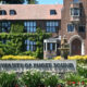 Campus fountain and a brick university building with a sign reading 'University of Puget Sound' in a well-kept garden F