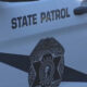White state patrol vehicle door with a black diagonal stripe, the State Patrol badge centered on the door, and the words STATE PATROL above the badge.