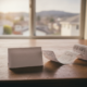 Receipt unfurling across a wooden table with a blank folded card nearby; windowed houses blurred in the background