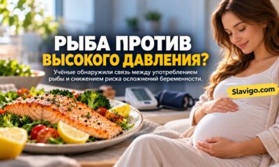 Беременная женщина за столом с приготовленной рыбой, овощами и крупой